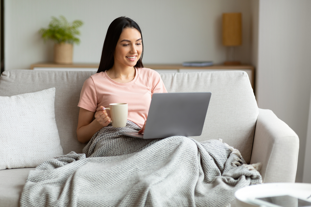 Woman having a coffee in a blanket 